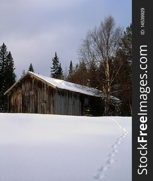 An old farmhouse in snowy landscape