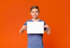 Free Cute Smiling Boy Holding White Blank Placard Stock Images - 145306434