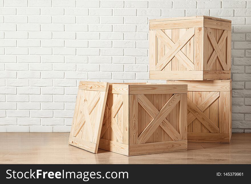 Wooden crates on floor near brick wall, space for text