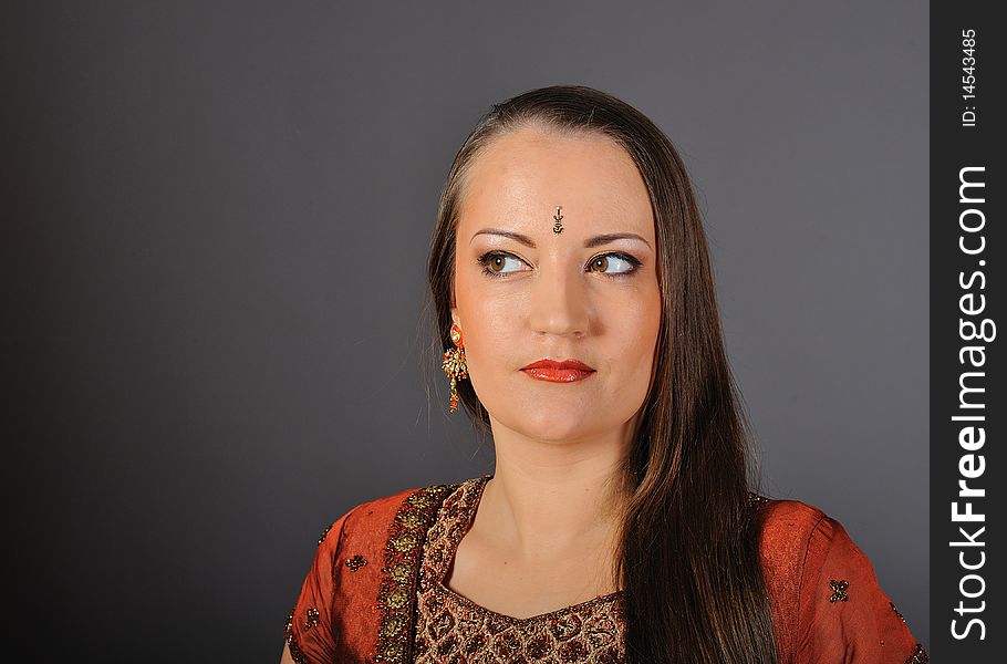 Young beautiful woman in indian traditional jewellary, bindi and sari dress. Young beautiful woman in indian traditional jewellary, bindi and sari dress.