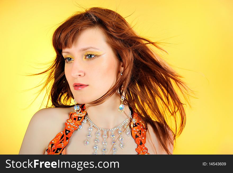 Beautiful woman with golden make-up. yellow background
