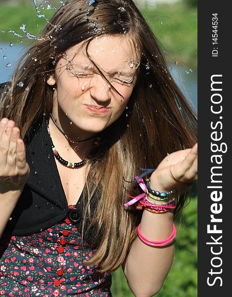 Beautiful teenage girl wash her face with pure water on nature background. Beautiful teenage girl wash her face with pure water on nature background