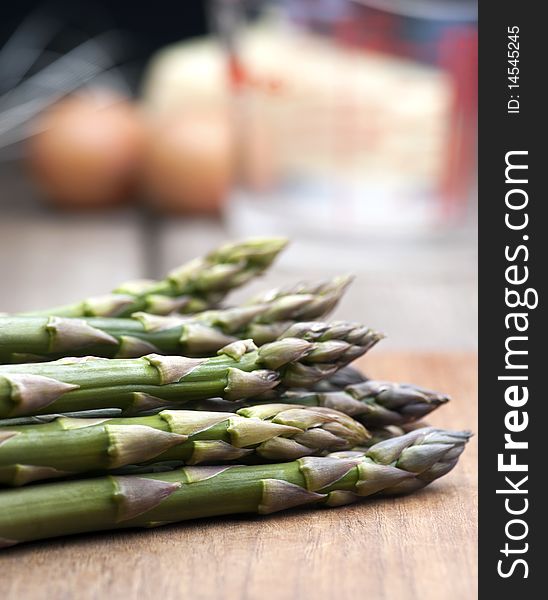 Fresh Asparagus Laid Out On A Wooden Chopping Board, With Ingredients For Hollandaise Sauce In The Background