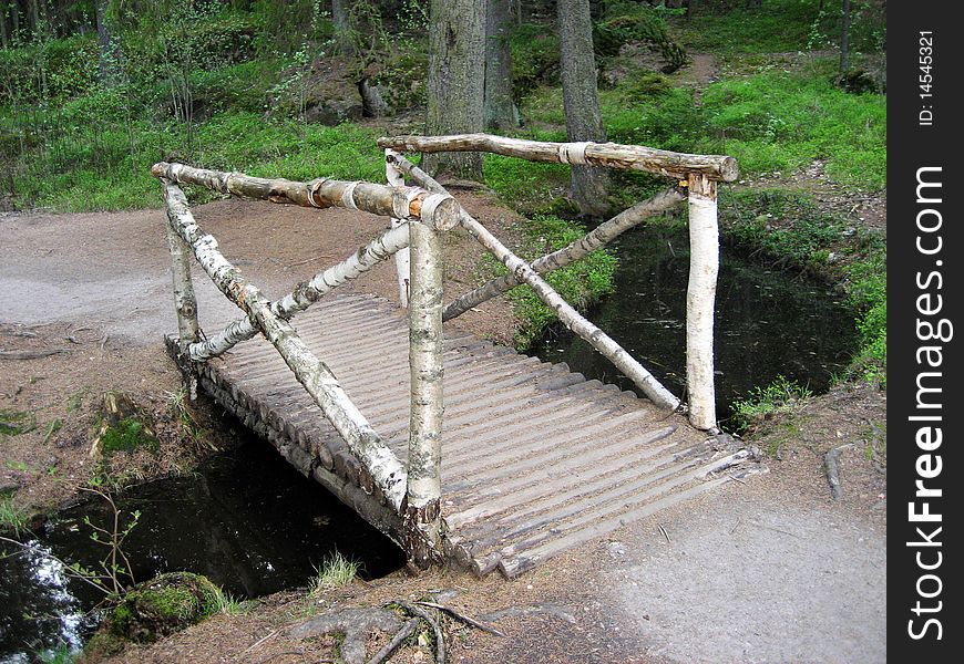Wooden bridge across small river in the park.