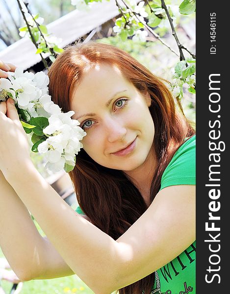 Young  woman standing at apple tree in white blossom. Young  woman standing at apple tree in white blossom