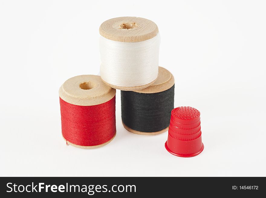 Cotton reels and thimble isolated on white