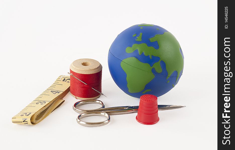 Sewing kit with a small globe representing the concept of mending the planet. Sewing kit with a small globe representing the concept of mending the planet