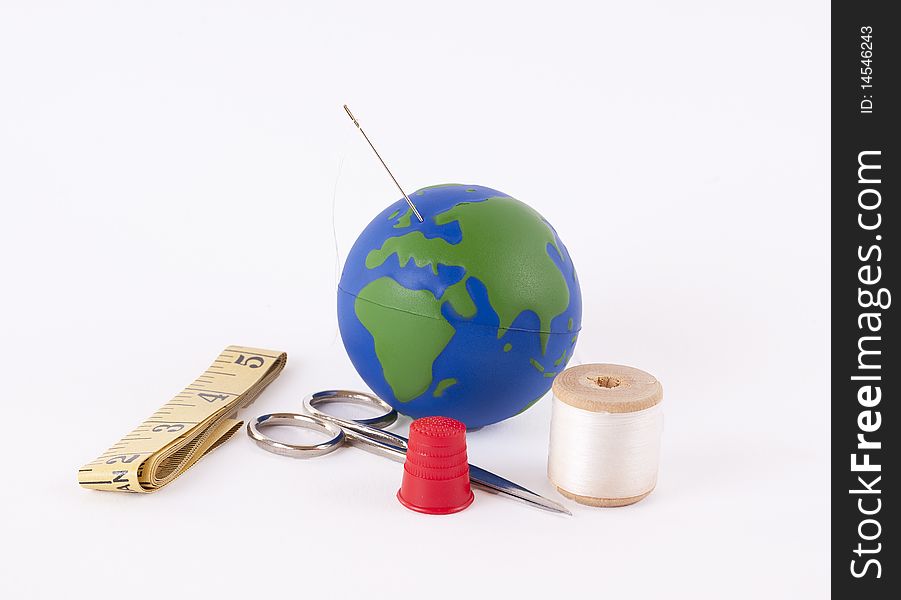 Sewing kit with a small globe representing the concept of mending the planet. Sewing kit with a small globe representing the concept of mending the planet