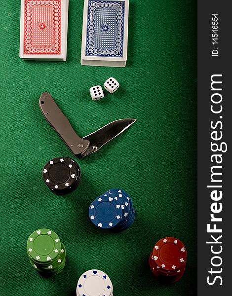 Casino gambling chips, cards and knife  on green table. Casino gambling chips, cards and knife  on green table