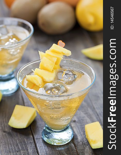 Cocktail of mango juice with ice cubes and pieces of fruit. Cocktail of mango juice with ice cubes and pieces of fruit