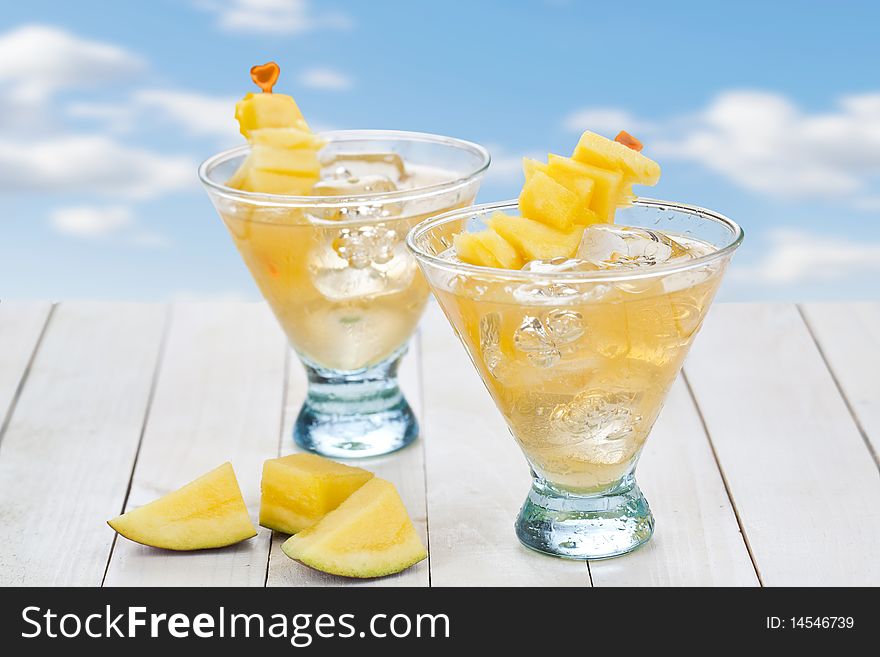 Cocktail of mango juice with ice cubes and pieces of fruit. Cocktail of mango juice with ice cubes and pieces of fruit