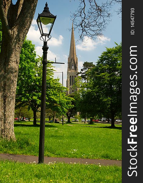 A lamp stands in a parkwith the steeple of Christchurch cathedral, Clifton, Bristol, England in the background. A lamp stands in a parkwith the steeple of Christchurch cathedral, Clifton, Bristol, England in the background