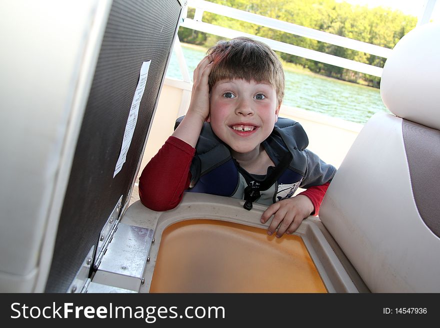 A smiling young boy onboard a boat. A smiling young boy onboard a boat.