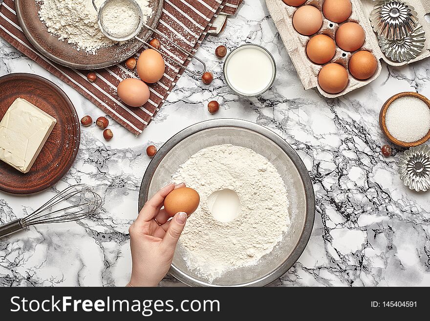 Close-up shot. Top view of a baker cook place, hands are working with a raw dough on the marble table background.