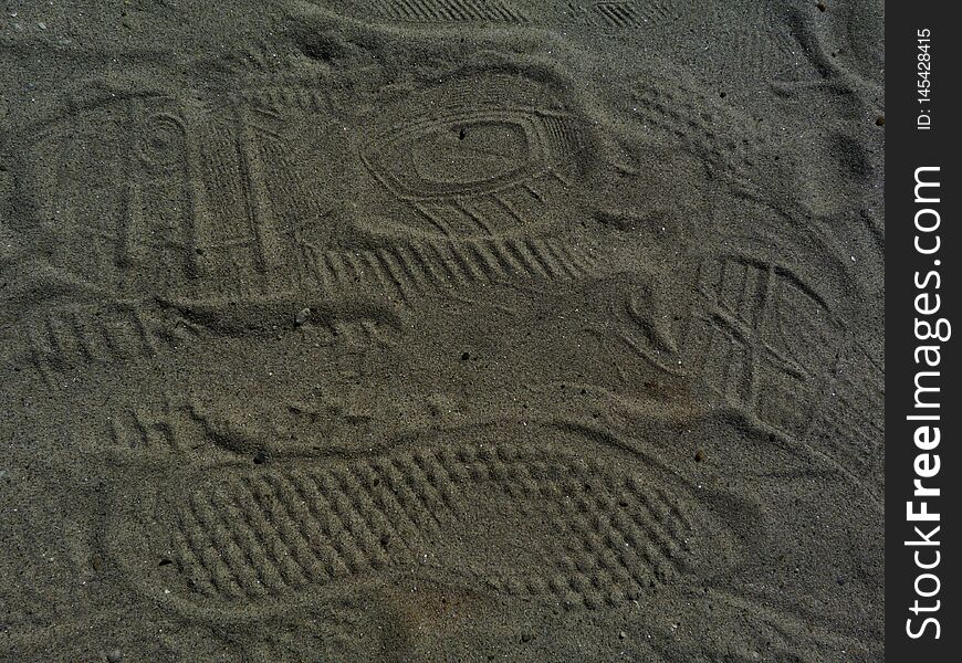 Shoe print abstract in fine grey sand. foot print patterns left in sand. background image.