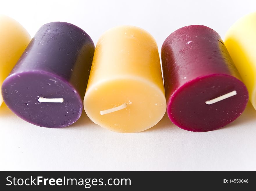 Colorful wax candle lying on white surface. Colorful wax candle lying on white surface