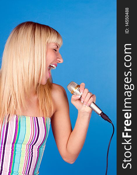 Funny blonde on a blue background with a microphone. Funny blonde on a blue background with a microphone