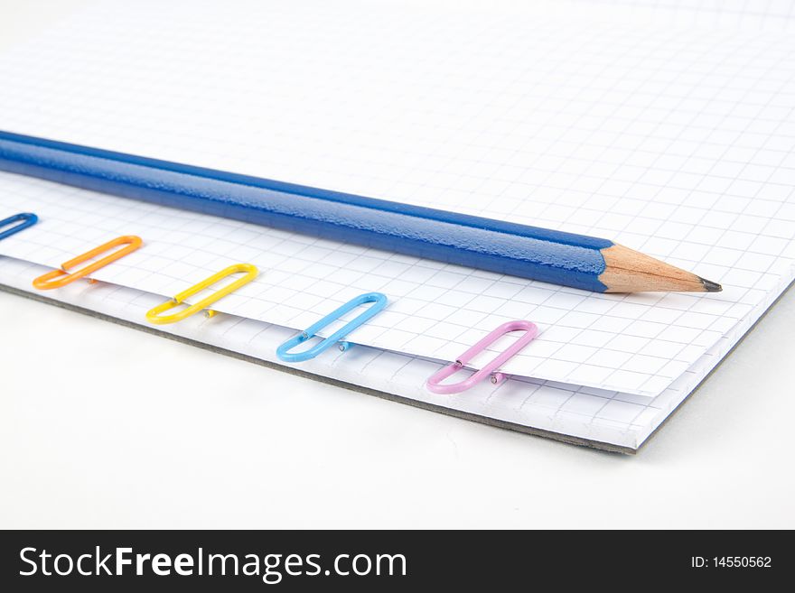 Paper clips and pencil on white background