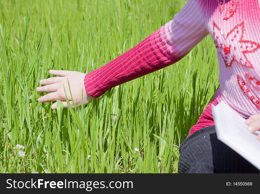 Girls hand over green grass. Girls hand over green grass