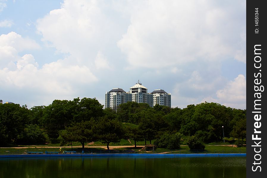 The many-storeyed House located against the sky of pond and trees