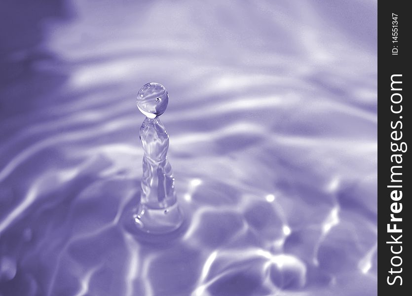 A water droplet frozen in motion moments before hitting the water