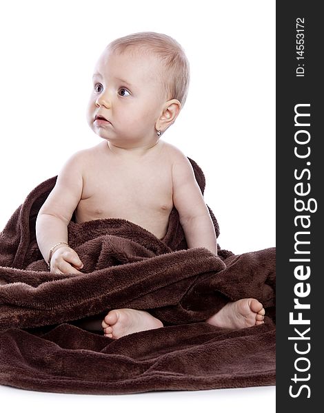 Beautiful baby under a brown towel on white background