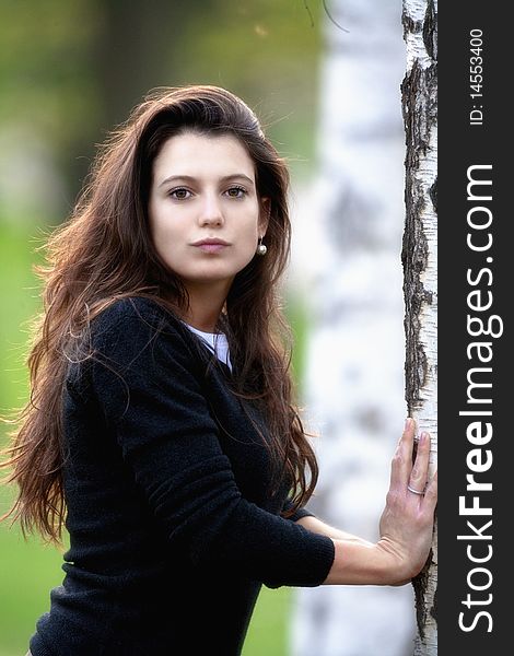 Portrait of a beautiful brunette standing in birch forest. Portrait of a beautiful brunette standing in birch forest