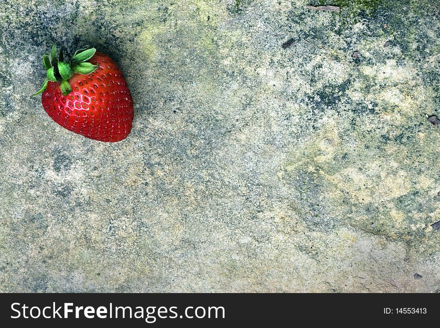 Beautiful red strawberry on textured grunge rock. Beautiful red strawberry on textured grunge rock