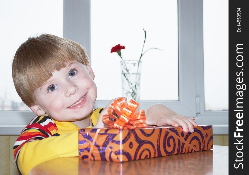 Portrait of the little boy with a gift box on a background. Portrait of the little boy with a gift box on a background