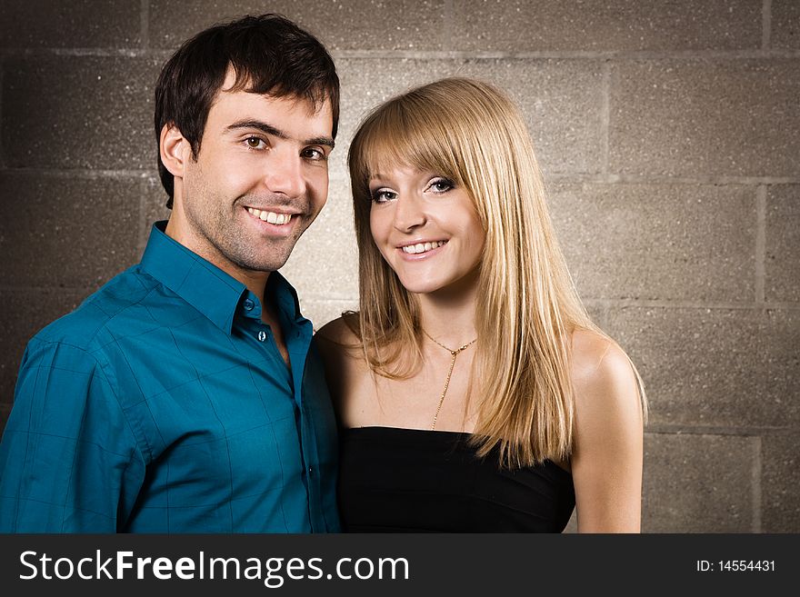 Young cheerful couple on brick wall background