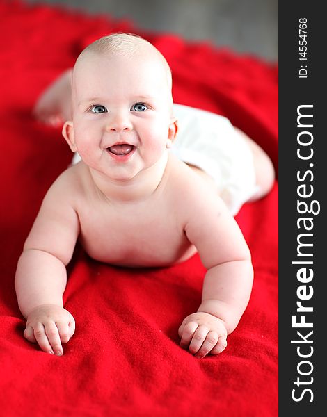 Little boy lying on red bed blanket. Little boy lying on red bed blanket.