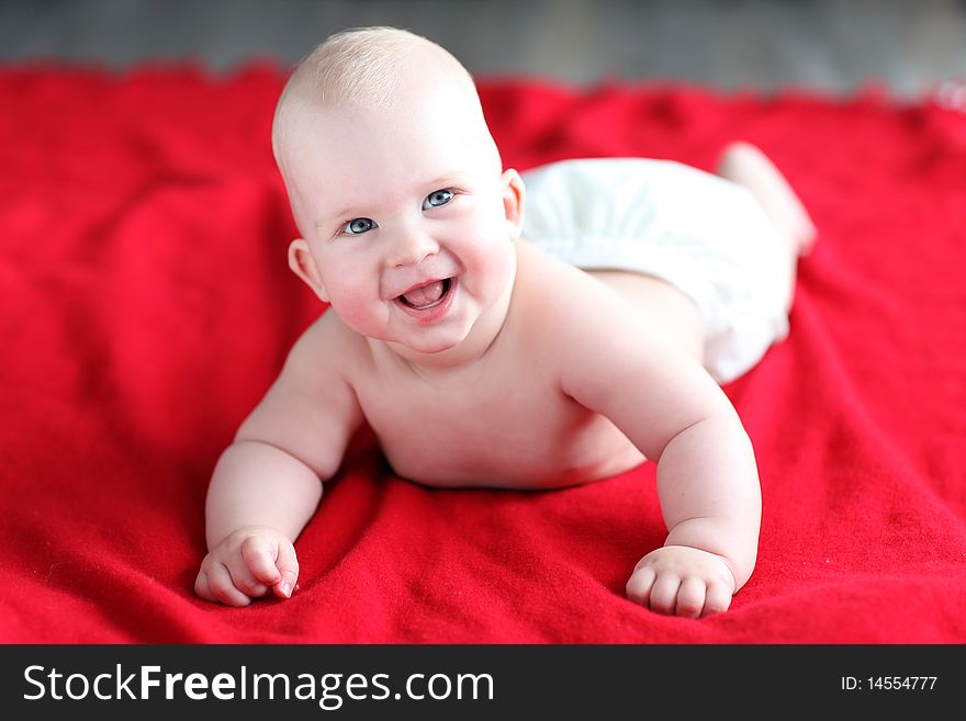 Little boy lying on red bed blanket. Little boy lying on red bed blanket.