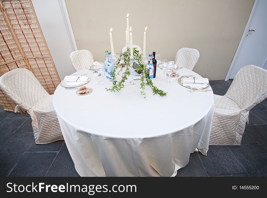 White wedding table with plates glasses and wine