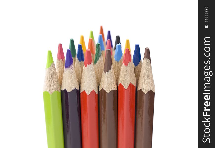 Several colored pencils stand together forming a triangle shape. Several colored pencils stand together forming a triangle shape.