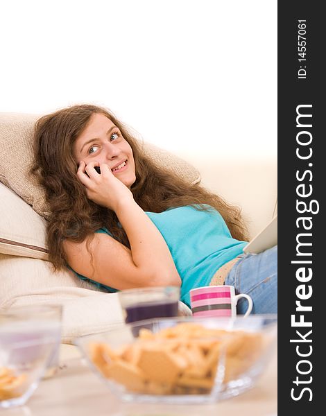 Attractive young girl lying on sofa and talking on phone