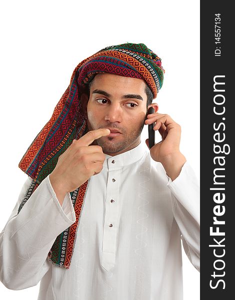 Pondering arab ethnic middle eastern businessman dressed in traditional clothing. He is using a mobile cellphone. White background. Pondering arab ethnic middle eastern businessman dressed in traditional clothing. He is using a mobile cellphone. White background.