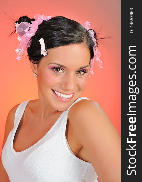 Beautiful happy smiling woman with natural make-up and funny hairstyle . pink background. Beautiful happy smiling woman with natural make-up and funny hairstyle . pink background