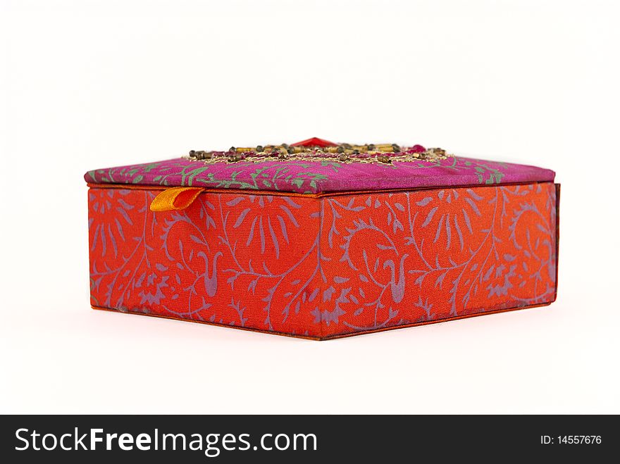 Square, red jewellery box with intriquite patterns and designs covering it. Square, red jewellery box with intriquite patterns and designs covering it