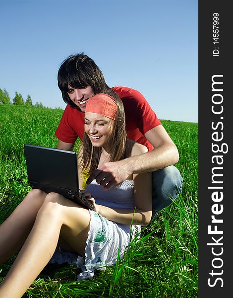 Beautiful girl with notebook and boy with smile on grass. Beautiful girl with notebook and boy with smile on grass