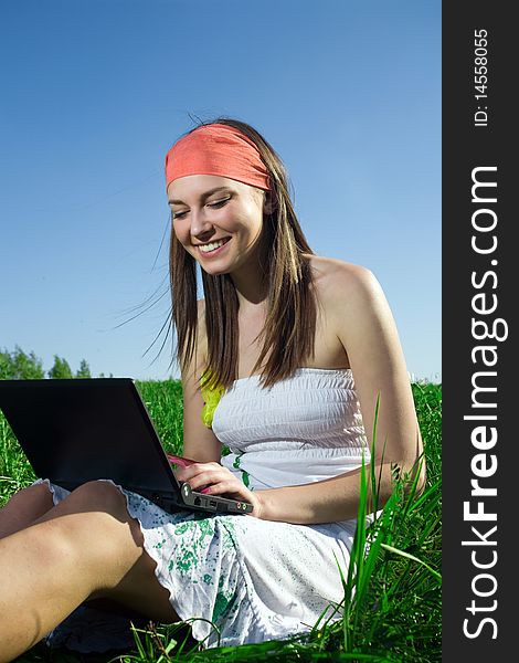Beautiful girl in white dress with notebook on grass. Beautiful girl in white dress with notebook on grass