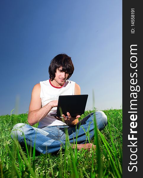 Boy in jeans with notebook on grass. Boy in jeans with notebook on grass