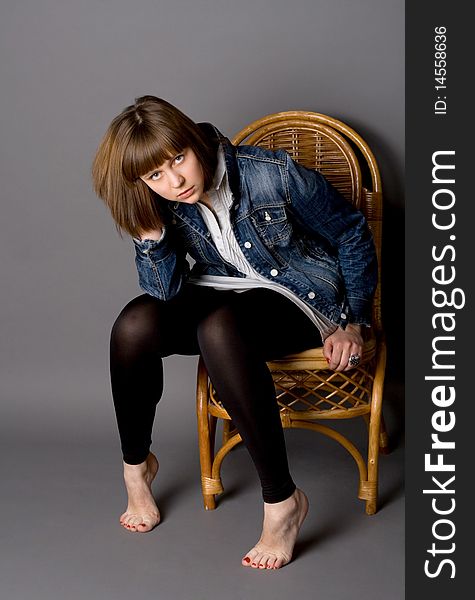 Attractive girl sitting on chair in studio