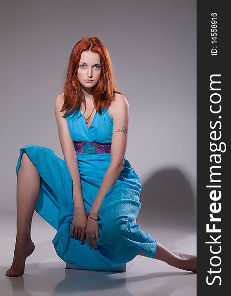Young beautiful red-haired woman on studio bakground. Young beautiful red-haired woman on studio bakground