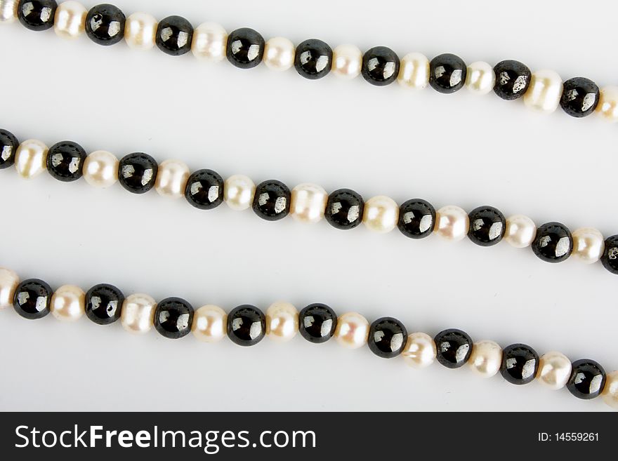 White pearls and black stone beads on a thread. White pearls and black stone beads on a thread