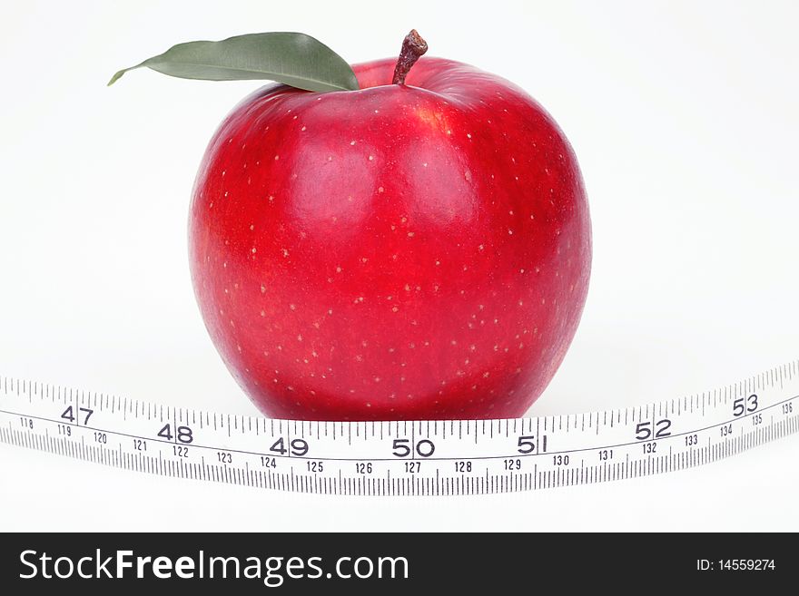 Red apple and measuring tape on a white background