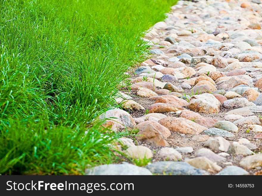 Stone roadway and lawn with a green grass