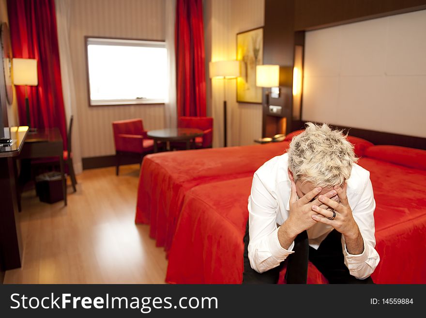 Portrait of an angry young business man sitting on a bed. Portrait of an angry young business man sitting on a bed.