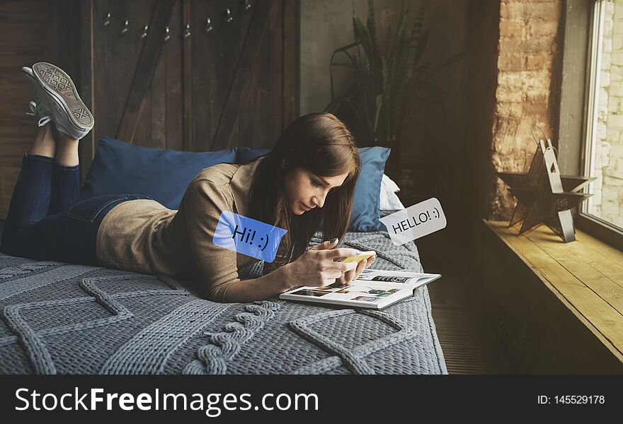 Happy young woman bed at home on couch texting her friend