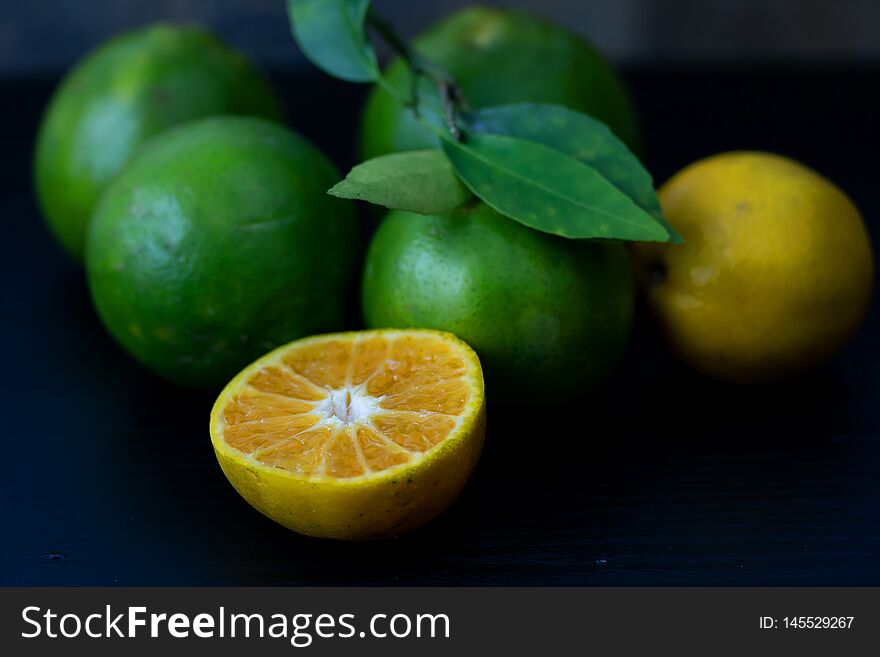 Fresh orange from the garden Cut half On the black wood table