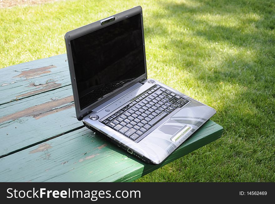 Laptop on a park bench in the day light